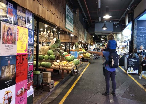 Ein Mann mit Kind auf den Schultern geht durch den Adelaide Central Market