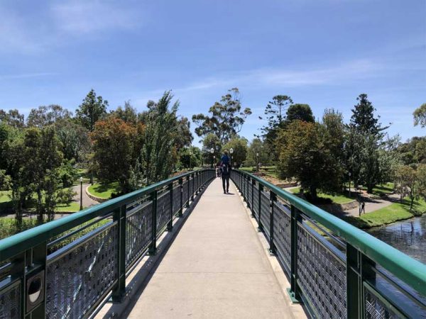 Ein Fußgänger geht auf einer Brücke über ein Fluss in Adelaide