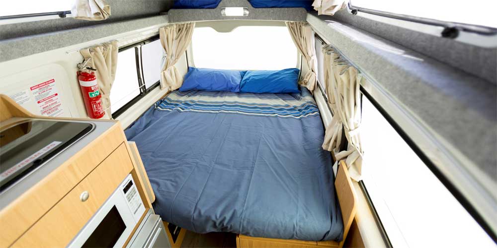 Ein Doppelbett in einem Hochdach-Camper