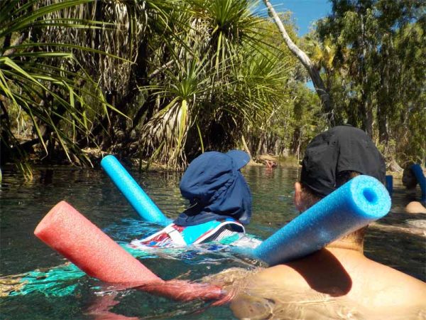 In den Bitter Springs im Northern Territory schwimmt ein Kind im Wasser mit einer Schwimmnudel.