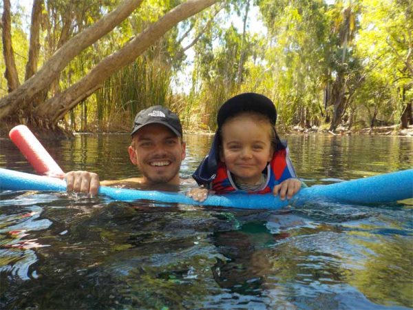 In den Bitter Springs im Northern Territory schwimmen ein Kind und sein Vater mit Hilfe von Schwimmnudeln im Wasser.