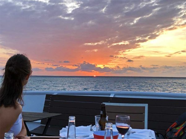 Eine Frau blickt in den Sonnenuntergang während einer Sunset Tour durch den Darwin Harbour.