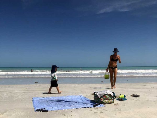 Ein Kind mit seiner Mutter am Strand in Broome, Australien
