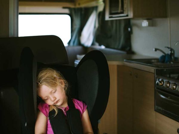 Ein Kind schläft im Kindersitz in einem Camper in Australien