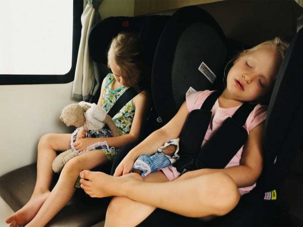 Zwei Kinder sitzen jeweils in einem Kindersitz auf einer Rückbank in einem Camper ©Photo: Britz/ Mark Clinton Zwei Kinder sitzen jeweils in einem Kindersitz auf einer Rückbank in einem Camper
