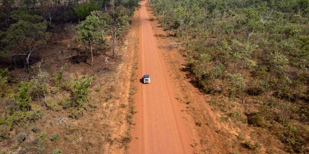 Ein Geländewagen auf einer Schotterstraße die bis zum Horizont reicht