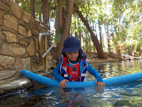 Ein Kind mit einer Pool-Noodel in den Thermal Pools von Mataranka, Australien