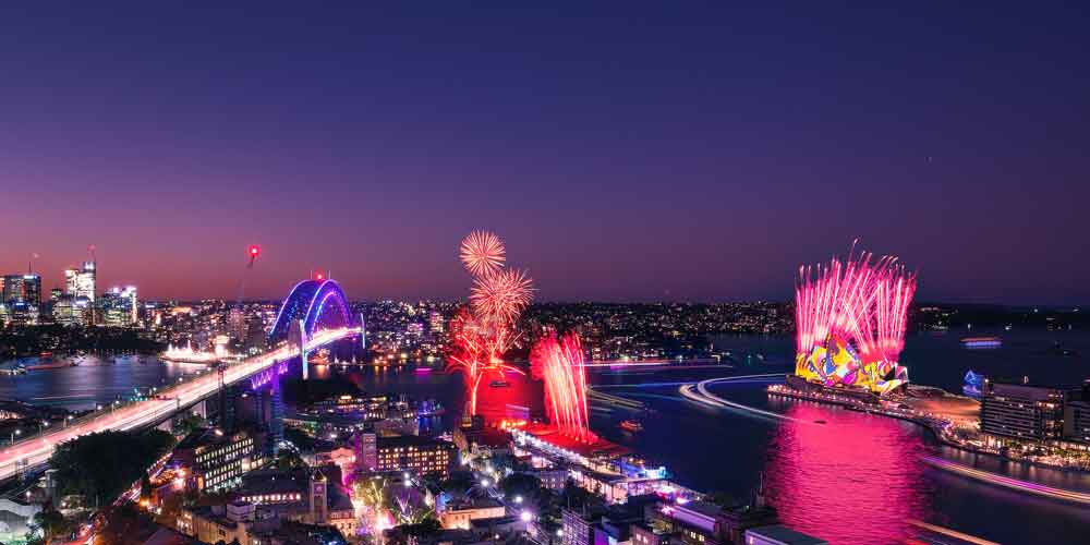 Eine Luftaufnahme vom Hafen von Sydney mit Feuerwerk während der VIVID Sydney 2022