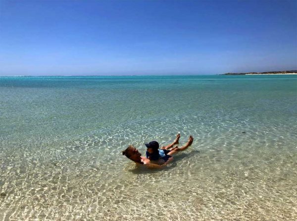 Vater und Sohn spielen im seichten Wasser an der Coral Coast